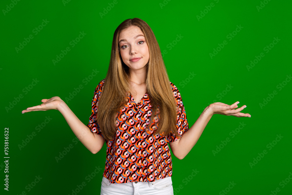 Photo of clueless indifferent girl with straight hairdo dressed print shirt shrug shoulders spread hands isolated on green color background Photo of clueless indifferent girl with straight hairdo dressed print shirt shrug shoulders spread hands isolated on green color background