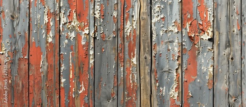 A close-up view of a weathered wooden fence with peeling paint, revealing a distressed and aged appearance. © FryArt