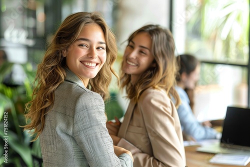 Wallpaper Mural Two young smiling women casually dressed in an office environment with indoor plants and natural light Torontodigital.ca