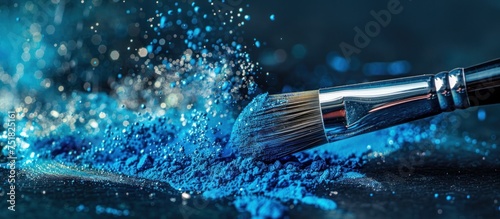 A close-up view of a silver brush loaded with vibrant blue paint, ready for use in an art project or home improvement task.