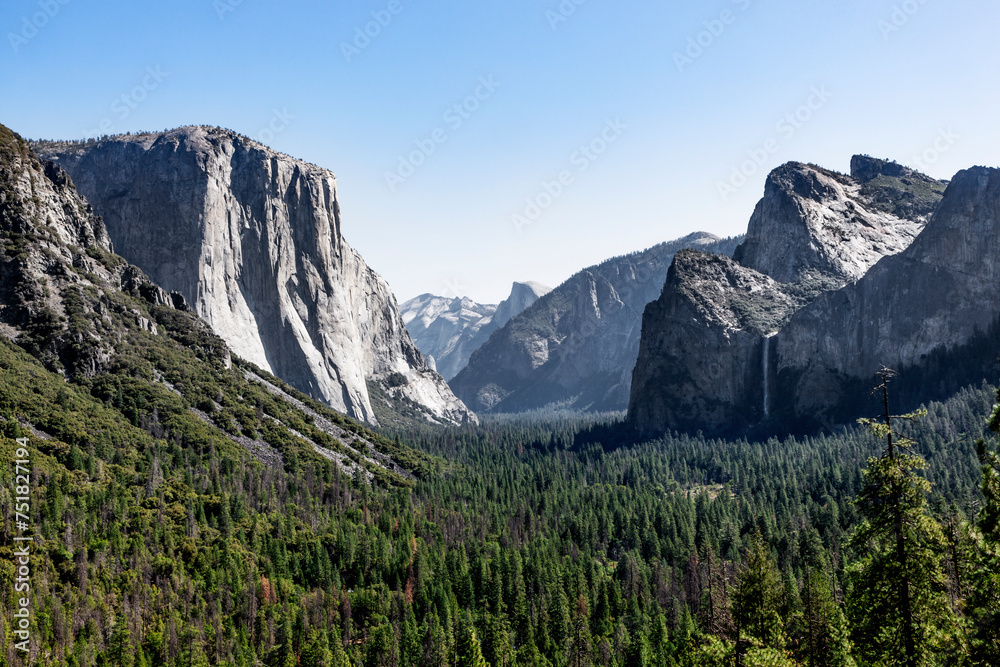 Fototapeta premium Blick in das Yosemite Valley auf El Capitan, Bridalvail Fall und Half Dome an einem klaren Sommermorgen