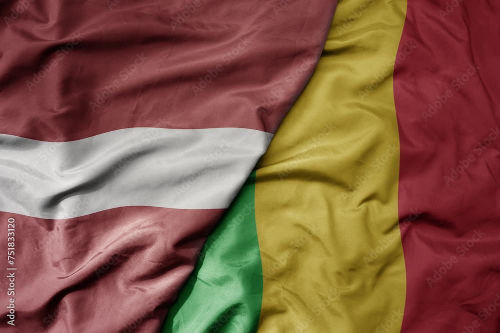 big waving national colorful flag of mali and national flag of latvia.