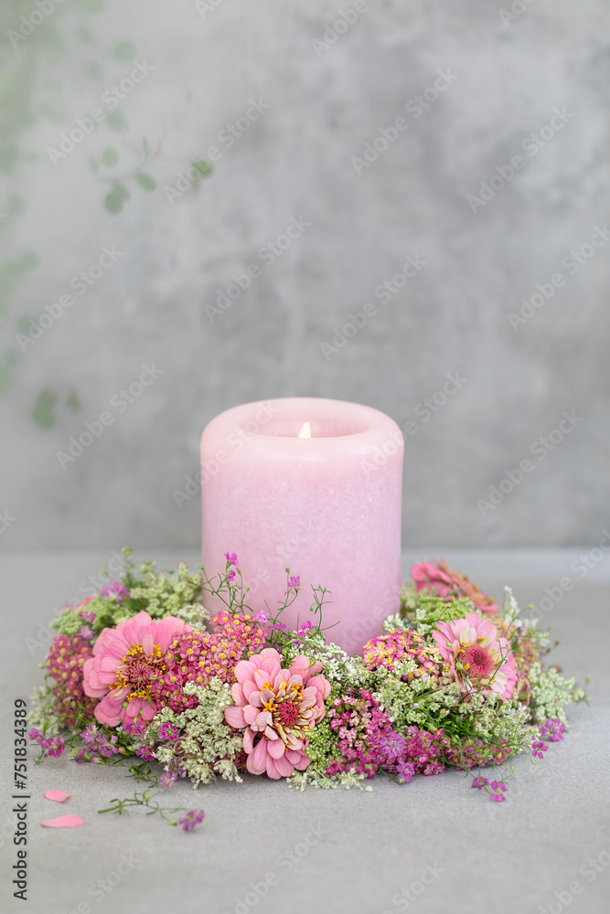 Różowa świeca otoczona wiankiem z letnich kwiatów. Cynie. - obrazy, fototapety, plakaty 