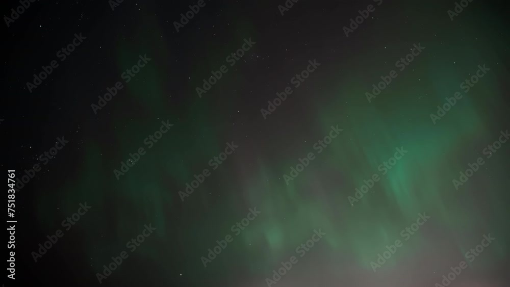 Bright northern lights with green shimmer and glow against background of the night sky with bright stars. Aurora borealis in night sky is an amazing play of colors in nature of northern part of world