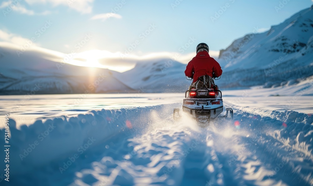 An adventurous person snowmobiling through a vast, snow-covered  mountains