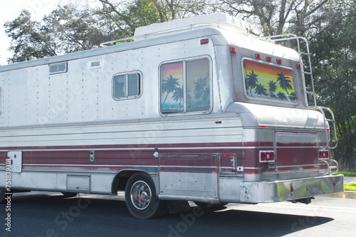 Large older late model vintage RV recreational vehicle driving down a paved road or highway. downsizing lifestyle.  independent people living the outdoor leisure activity and wanderlust life lifestyle