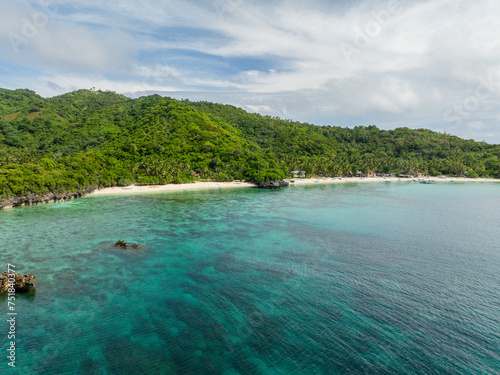 Greenish water with coral reefs and white sand beach. Cobrador Island. Romblon, Philippines.