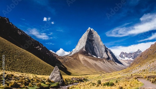 a triangular rock in a vally under a deep blue sky in the andes photo