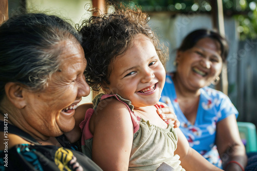 Candid outdoor shot capturing a joyful family moment with three generations of South American women laughing together, embodying warmth and unity.