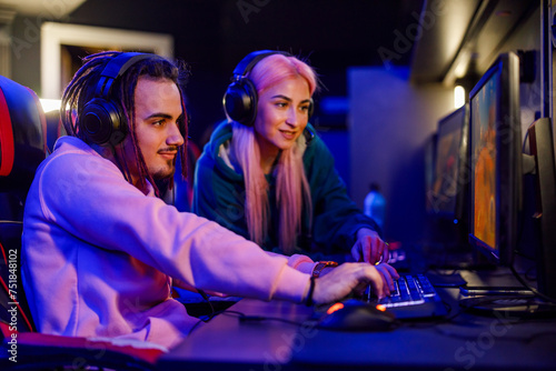 Professional male gamer and his female friend playing online strategy video game