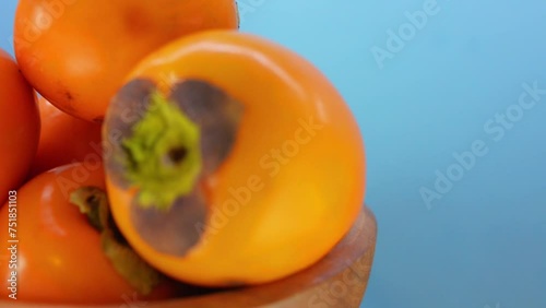 ripe persimmon in wooden plate photo