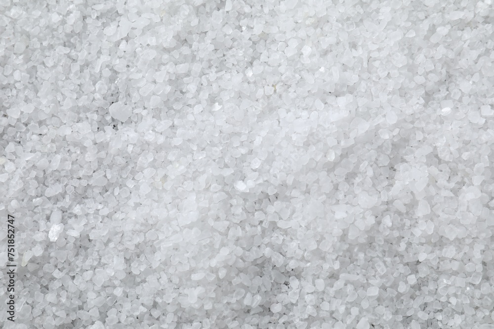 White natural salt as background, top view