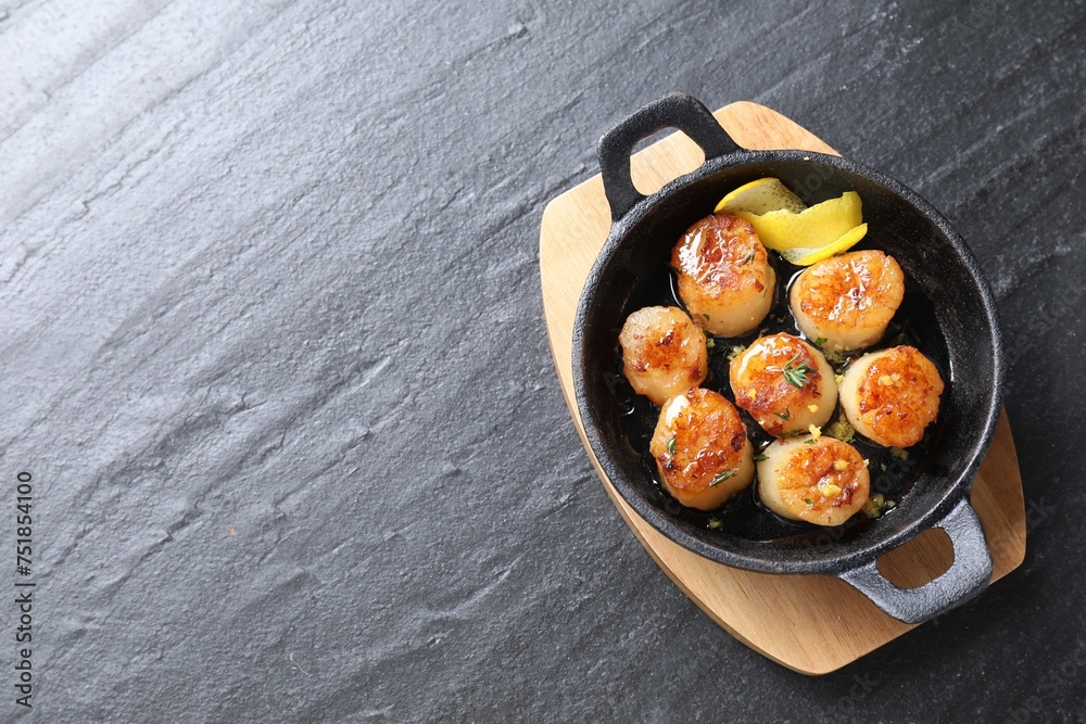 Delicious fried scallops on dark gray textured table, top view. Space for text