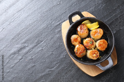 Delicious fried scallops on dark gray textured table, top view. Space for text