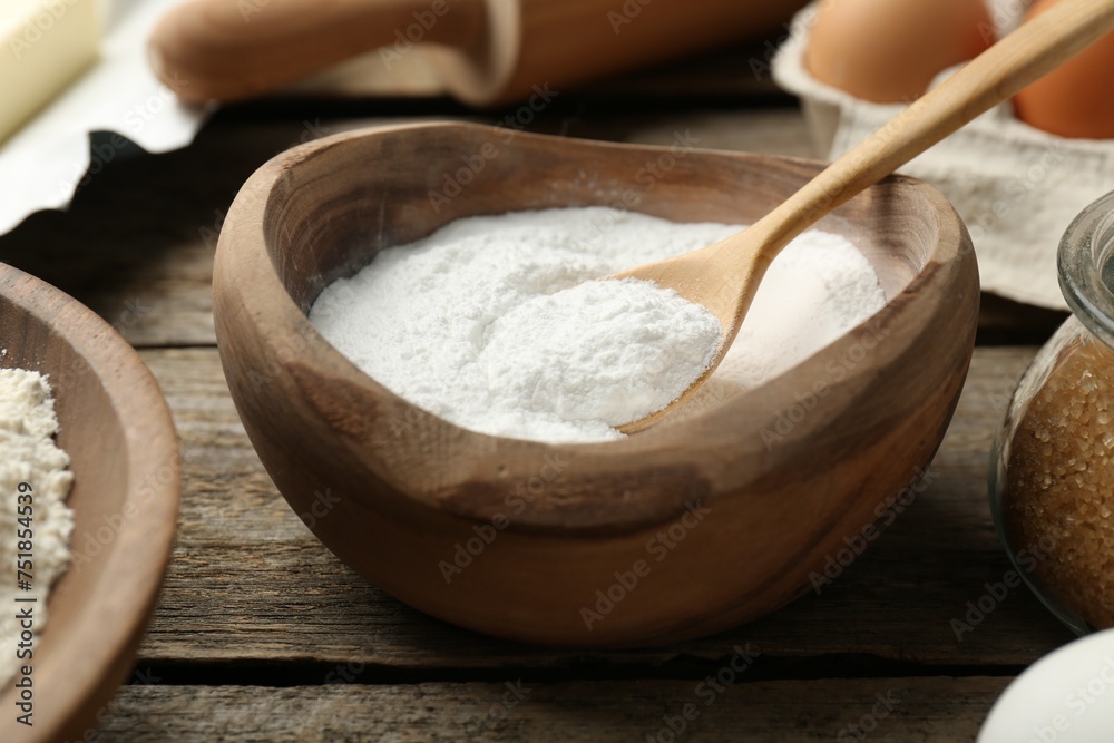 Fototapeta premium Baking powder and other ingredients for making dough on wooden table, closeup