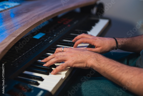 Musician's hands playing on a synthesizer keyboard photo