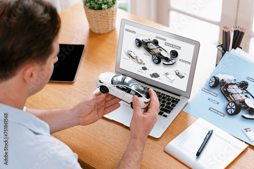Car design engineer analyze car prototype for automobile business at home office. Automotive engineering designer carefully analyze, finding flaws and improvement for car model design. Synchronos