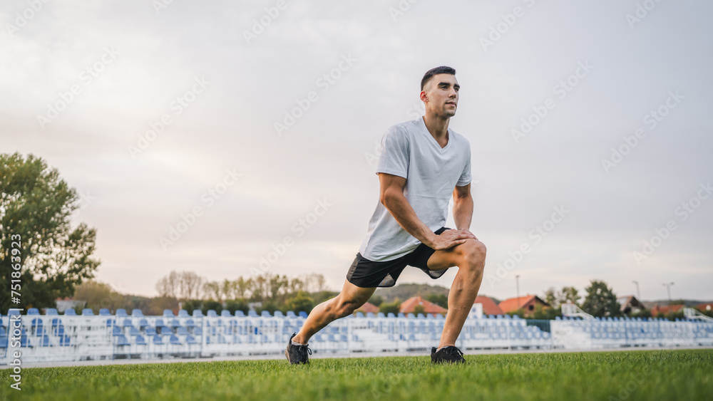one man male athlete stretch outdoor at stadium track one man male athlete stretch outdoor at stadium track