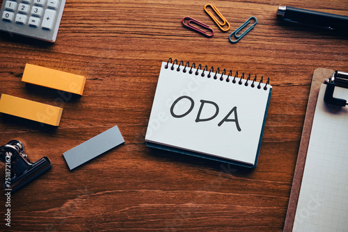 There is notebook with the word ODA. It is an abbreviation for Official Development Assistance as eye-catching image. photo