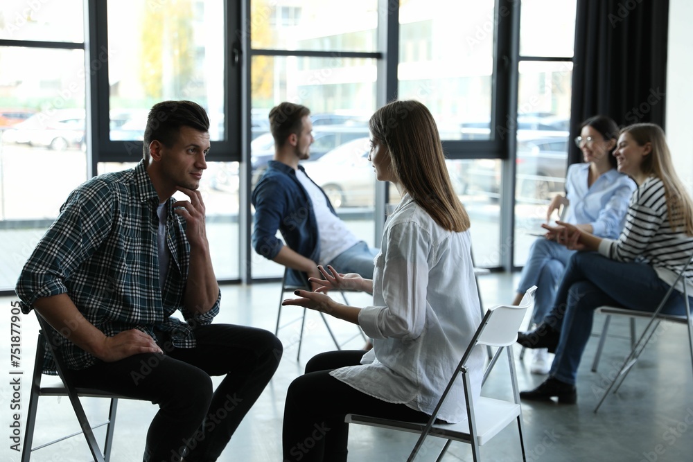 Psychotherapist working with patient in group therapy session indoors Psychotherapist working with patient in group therapy session indoors