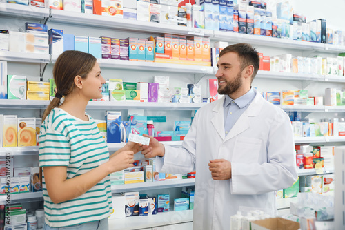 Professional pharmacist giving pills to customer in modern drugs