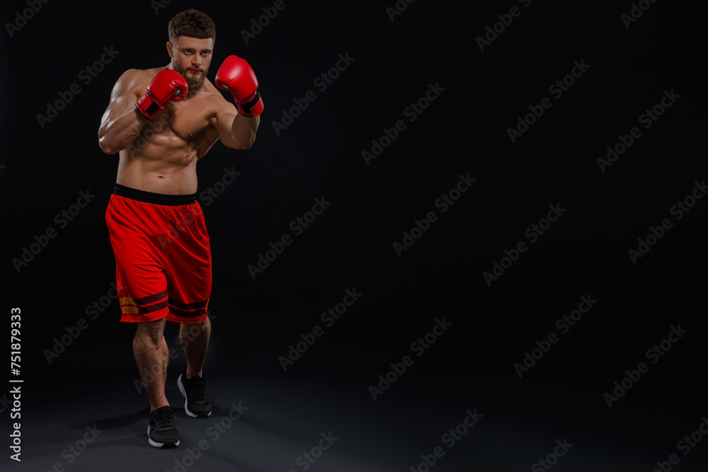 Man in boxing gloves fighting on black background. Space for text Man in boxing gloves fighting on black background. Space for text