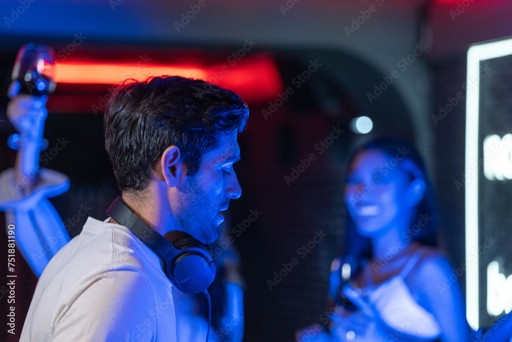 DJ musician man playing and mixing a song with a turntable and headphone. Dance party. excited dj sound device operator with headphones by dancing at club. concept of entertainment in nightlife. DJ musician man playing and mixing a song with a turntable and headphone. Dance party. excited dj sound device operator with headphones by dancing at club. concept of entertainment in nightlife.