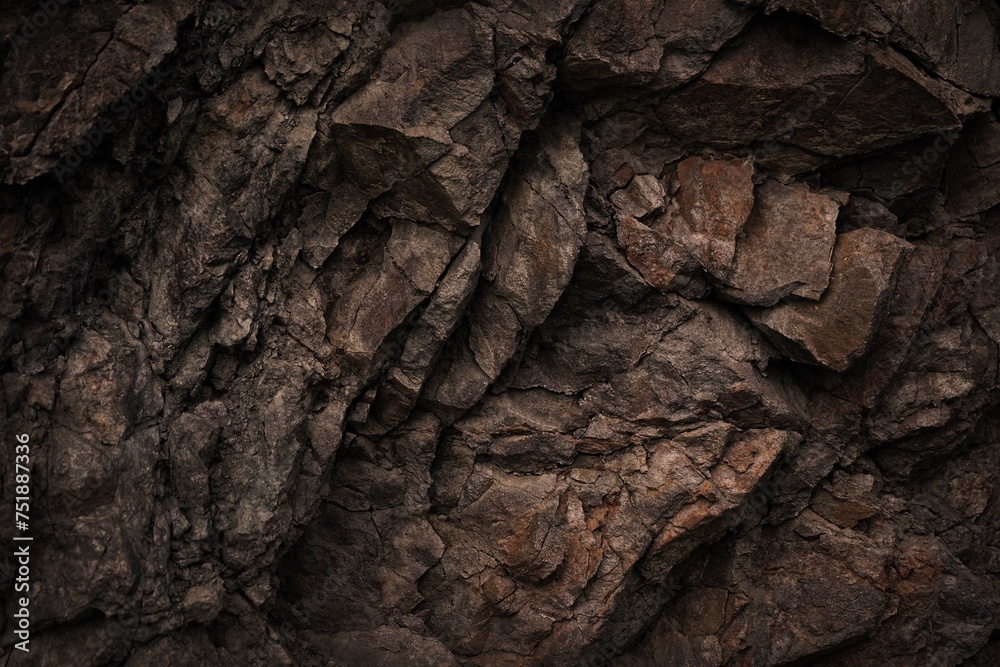 Black dark brown gray stone rock granite basalt texture background. Mountains surface. Close-up. Cracked broken crumbled.