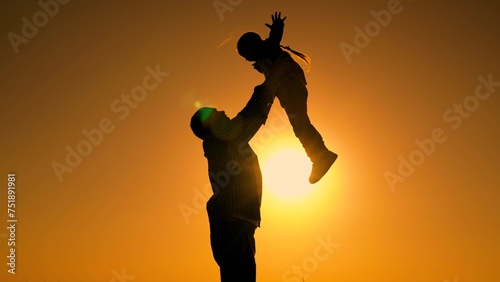 Dad is playing with child in park, girl dreams of fly. Father throws happy baby daughter into sky. Family game with child in outdoor. Happy family concept, childhood dream to fly. Dad kid daughter sun