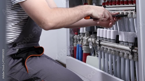 Plumber work. Installing collector for warm water underfloor heating system.