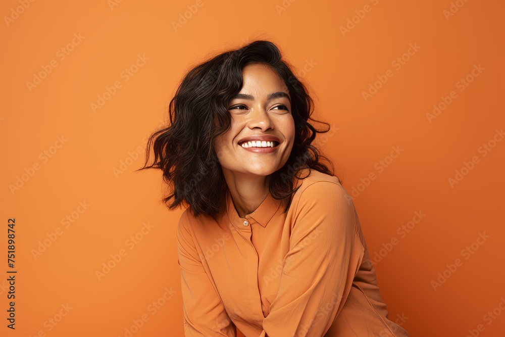 Portrait of happy smiling young woman looking at camera over orange background Portrait of happy smiling young woman looking at camera over orange background