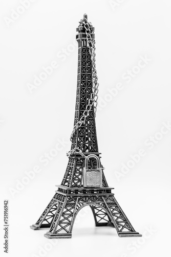 Fototapeta Naklejka Na Ścianę i Meble -  Miniatura de torre Eiffel cerrada con cadena y candado, aislado en blanco