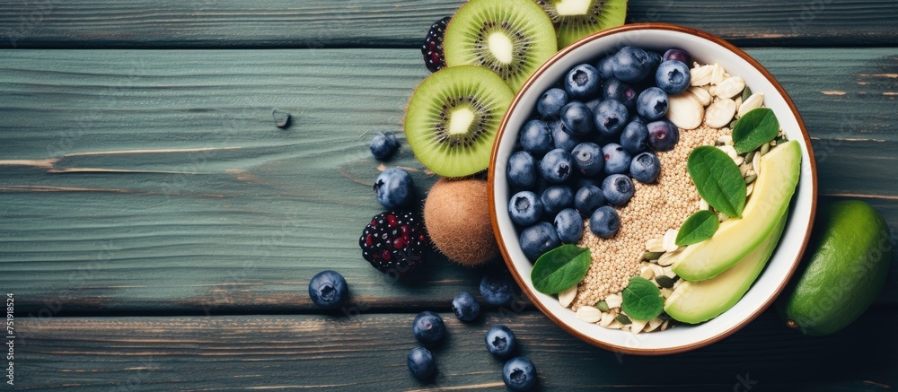 A bowl filled with a delicious and colorful breakfast ensemble, featuring fresh kiwis, plump blueberries, and crunchy granola. The vibrant mix of textures and flavors creates a satisfying and - obrazy, fototapety, plakaty 