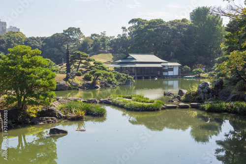 traditional japanese house on the pond surrounded with green forest in kiyosumi park in tokyo photo