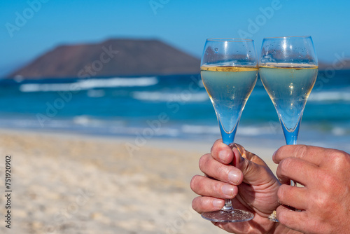 Pouring a glass of champagne on vacation, south of Fuerteventura, Canary islands, blue ocean, mountains photo