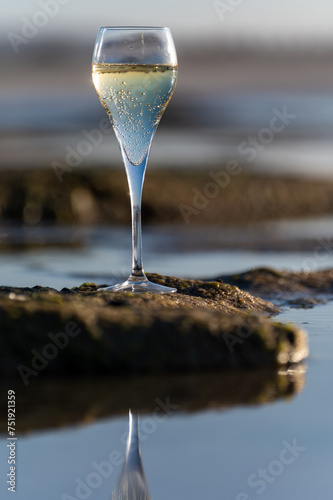 A glass of champagne or cava on vacation, low tide on Dunes Corralejo sandy beach, Fuerteventura, Canary islands