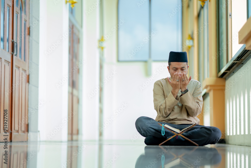 Ramadan, Quran, Islam, An Asian Muslim man is sitting and reading the Quran. The peace in the mosque makes it an energetic atmosphere of faith, with copy space. Ramadan, Quran, Islam, An Asian Muslim man is sitting and reading the Quran. The peace in the mosque makes it an energetic atmosphere of faith, with copy space.