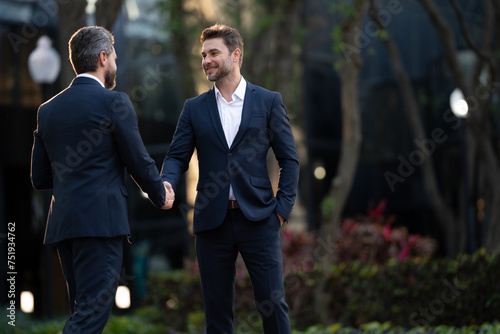 Businessman handshake for teamwork ,successful. Business network concept. Management strategy. Human resources. businessman greeting and making handshake with a businessman outdoors in city walkway.