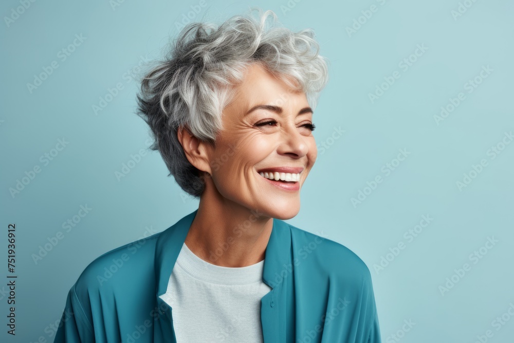 Portrait of smiling senior woman with grey hair on blue background. Portrait of smiling senior woman with grey hair on blue background.