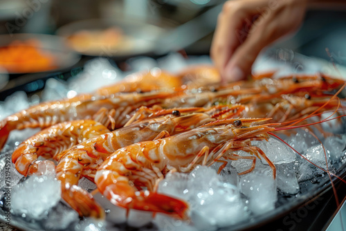 A hand grabbing a brown shrimp from a pile on the table, food culinary