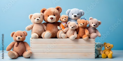 Toy box full of baby kid toys. Container with teddy bear, fluffy and educational wooden toys on light blue background. Cute toys collection for small children. Front view  © EA Studio
