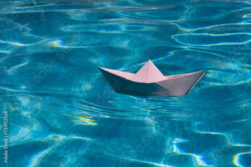 Origami ship. Paper ship sail. Paper boat on the sea water background. Dreaming traveling. © Volodymyr