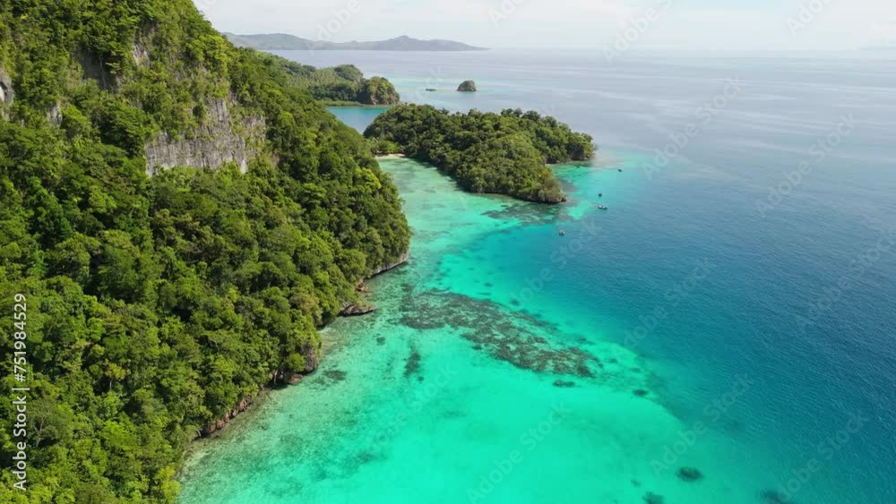 cinematic drone flight alongside island mountain with snorkelers in the water. cinematic drone flight alongside island mountain with snorkelers in the water.