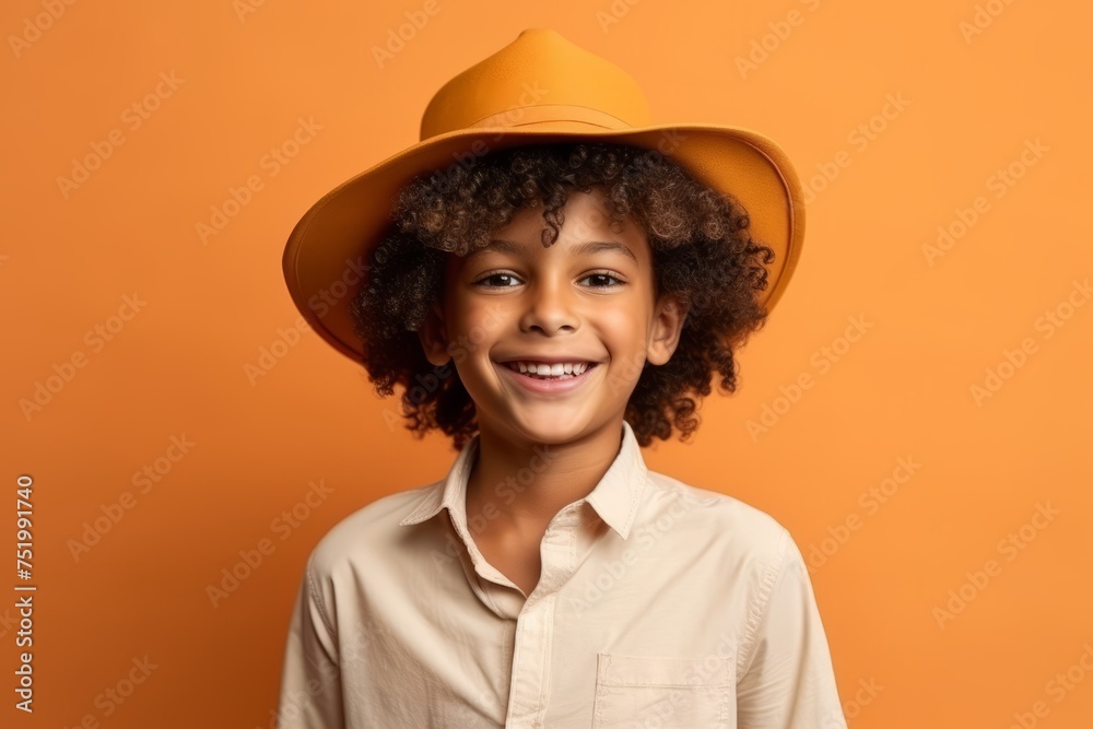 Portrait of a cute african american little boy in hat on orange background Portrait of a cute african american little boy in hat on orange background