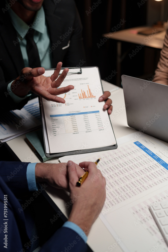 Confident group of business people pointing to graphs and charts to analyze market data, balance sheet, account, net profit, to plan sales strategy, startup business concept. Confident group of business people pointing to graphs and charts to analyze market data, balance sheet, account, net profit, to plan sales strategy, startup business concept.