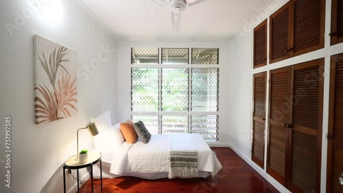 Dolly Between Doorframe to Modern Home Interior Wooden Flooring Elevated Property Small Bedroom and Jalousie Windows. House for real estate property. photo