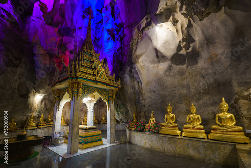 
The golden Buddha statues are placed inside a cave at Tham Khao Yoi Temple in Phetchaburi Province. It's a beautiful tourist attraction in Thailand. photo