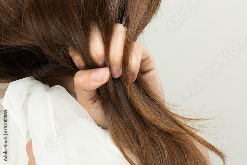ヘアダメージ : 女性は髪の毛を鷲掴みにしている.