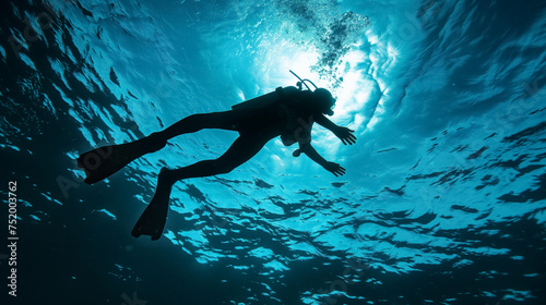 Scuba diver swimming in deep blue water.