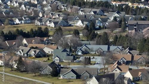 Beautiful idyllic residential area in America at sunny day. American Upper class Community with american craftsman style. Aerial zoom shot. Panning shot.